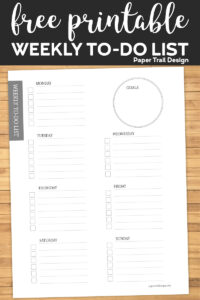 To-do list for each day of the week and a place to write your goal on wood background with text overlay- free printable weekly to do list