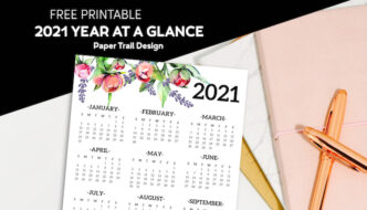 2021 one page calendar with floral elements lying on a stack of notebooks and a pen with text overlay- free printable 2021 year at a glance