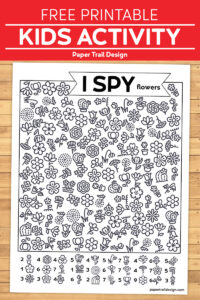 I spy flowers activity page with black and white flowers scattered thoughout the page on wood background with text overlay- free printable kids activity