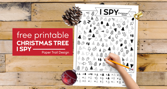 Christmas tree themed I spy activity with kid's hand holding pencil with text overlay- free printable Christmas tree I spy