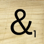 scrabble tile ampersand with wood background